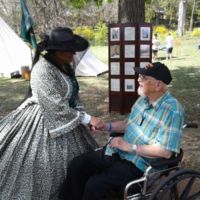 Victorian woman dressed to the 9s, and John.