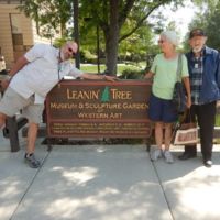 Bob leanin over the Leanin Tree sign, and Sally & John